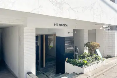a building with a sign that says six woman at S-K MANSION in Tokyo