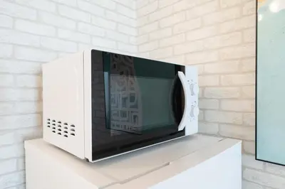 a microwave oven sitting on top of a white shelf at Kisa in Tokyo