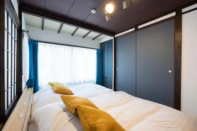 a bedroom with a large bed with blue walls and pillows at Kisa in Tokyo