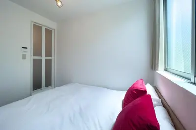 a white bed with pink pillows in a bedroom at \u30a8\u30ec\u30ac\u30f3\u30c8\u30cf\u30a6\u30b9 in Tokyo