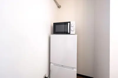 a microwave sitting on top of a white refrigerator at \u30a8\u30ec\u30ac\u30f3\u30c8\u30cf\u30a6\u30b9 in Tokyo