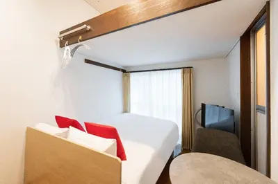 a room with a bed and a chair and a television at \u30b0\u30ea\u30fc\u30f3 \u30d2\u30eb in Tokyo