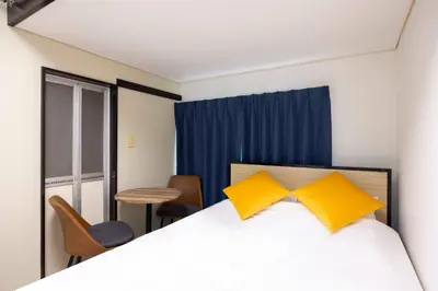 a bedroom with a bed with two yellow pillows at \u30b0\u30ea\u30fc\u30f3 \u30d2\u30eb in Tokyo
