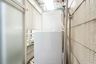 a small white refrigerator in a hallway with a wall at \u30b0\u30ea\u30fc\u30f3 \u30d2\u30eb in Tokyo