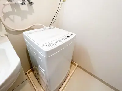 a washing machine in a bathroom next to a toilet at \u30b3\u30b9\u30e2\u30ea\u30fc\u30c9\u5357\u9ebb\u5e03 in Tokyo