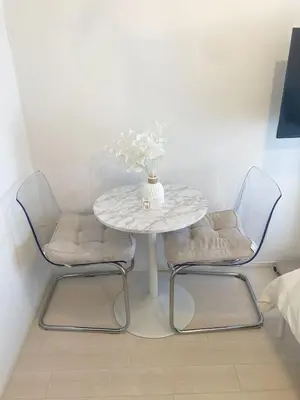 a table with two chairs and a vase with flowers on it at 4 min walk from Shibuya Station! (From A0 Exit) in Tokyo