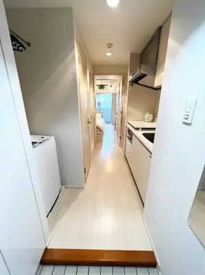 a hallway leading to a kitchen with white appliances at 4 min walk from Shibuya Station! (From A0 Exit) in Tokyo