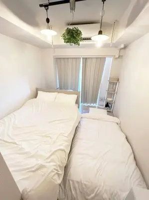 a white bed in a room with a window at 4 min walk from Shibuya Station! (From A0 Exit) in Tokyo