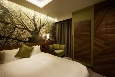 a bedroom with a bed and a tree painting on the wall at ALFIT HOTEL & BAR AKASAKA in Tokyo
