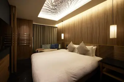 a bedroom with a large white bed with a skylight at ALFIT HOTEL & BAR AKASAKA in Tokyo