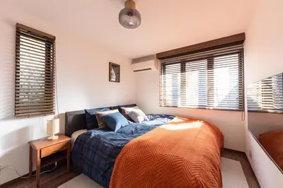 a bedroom with a bed and two windows at Shibuya-ku - Apartment - Vacation STAY 72295v in Tokyo