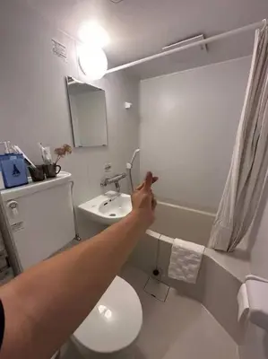 a person pointing to a bathroom with a toilet and a sink at Sky hotel \u775b\u7a7a\u5854\u70ed\u95e8\u65c5\u6e38\u666f\u533a \u6700\u8fd1\u8f66\u7ad9\u6b65\u884c3\u5206\u949f \u673a\u573a\u76f4\u8fbe \u5468\u8fb9\u6709\u4fbf\u5229\u5e97 \u5546\u573a \u6e29\u6cc9 \u8d2d\u7269\u9910\u996e\u65b9\u4fbf in Tokyo