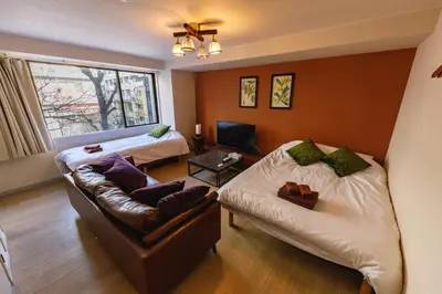 a living room with two beds and a couch at Azabukumai building in Tokyo