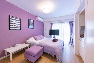 a bedroom with a bed and a purple wall at Azabukumai building in Tokyo