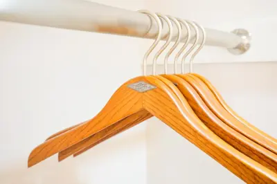 a bunch of wooden hoses hanging from a pipe at Azabukumai building in Tokyo