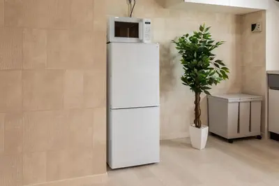 a white refrigerator with a microwave on top of it at Azabukumai building in Tokyo