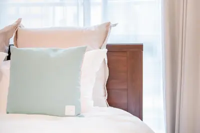 a bedroom with a bed with white pillows and a window at walk to Higahsi Shinjuku sta. EEY in Tokyo