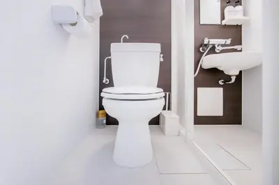 a white bathroom with a toilet and a sink at walk to Higahsi Shinjuku sta. EEY in Tokyo