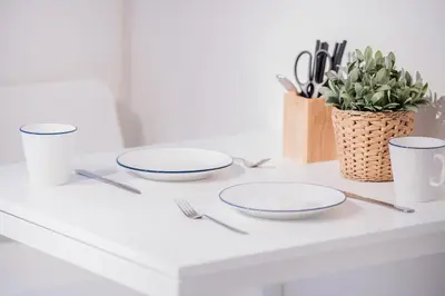 a white counter with plates and utensils on it at walk to Higahsi Shinjuku sta. EEY in Tokyo