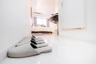 a white living room with a pile of pillows on the floor at walk to Higahsi Shinjuku sta. EEY in Tokyo