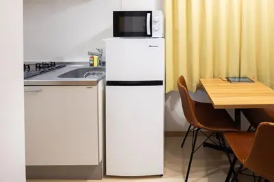 a white refrigerator with a microwave on top of it at \u30d1\u30a4\u30f3\u30b3\u30fc\u30c8 in Tokyo