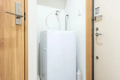 a white refrigerator in a bathroom next to a door at \u30d1\u30a4\u30f3\u30b3\u30fc\u30c8 in Tokyo