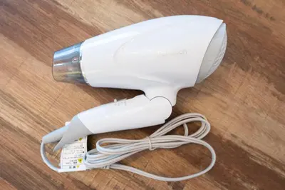 a white hair dryer with a bottle on a table at \u30d1\u30a4\u30f3\u30b3\u30fc\u30c8 in Tokyo