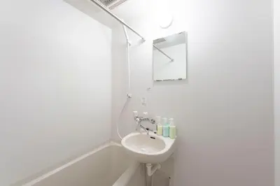 a white bathroom with a sink and a mirror at \u30d1\u30a4\u30f3\u30b3\u30fc\u30c8 in Tokyo