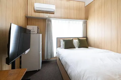 a hotel room with a bed and a television at \u30d1\u30ed\u9577\u5d0e in Tokyo