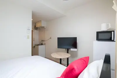 a small bedroom with a bed and a tv at \u30d1\u30ed\u9577\u5d0e in Tokyo