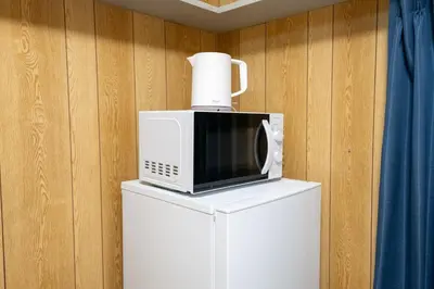 a microwave sitting on top of a refrigerator at \u30d1\u30ed\u9577\u5d0e in Tokyo