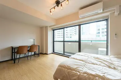 a bedroom with a bed and a desk and a large window at \u30e9\u30a4\u30ef\u30de\u30f3\u30b7\u30e7\u30f3\u5357\u9ebb\u5e03 in Tokyo