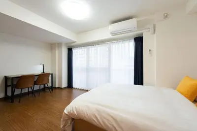 a bedroom with a bed and a desk and a window at \u30e9\u30a4\u30ef\u30de\u30f3\u30b7\u30e7\u30f3\u5357\u9ebb\u5e03 in Tokyo