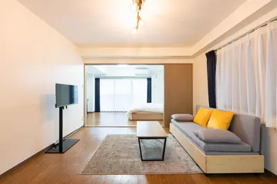 a living room with a couch and a bed at \u30e9\u30a4\u30ef\u30de\u30f3\u30b7\u30e7\u30f3\u5357\u9ebb\u5e03 in Tokyo