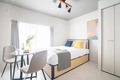 a bedroom with a bed and a table and chairs at \u30e9\u30eb\u30fc\u30ca\u6771\u6c60\u888b in Tokyo