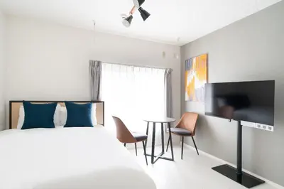 a bedroom with a bed and a flat screen tv at \u30e9\u30eb\u30fc\u30ca\u6771\u6c60\u888b in Tokyo