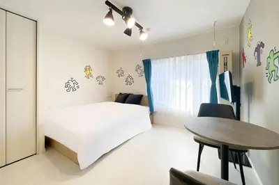 a bedroom with a white bed and a table at \u30e9\u30eb\u30fc\u30ca\u6771\u6c60\u888b in Tokyo