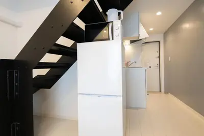 a kitchen with a refrigerator and a staircase at \u30e9\u30eb\u30fc\u30ca\u6771\u6c60\u888b in Tokyo