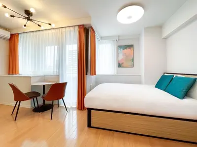 a bedroom with a bed and a table and chairs at \u30eb\u30fc\u30c1\u30a7\u9ad8\u8f2a in Tokyo