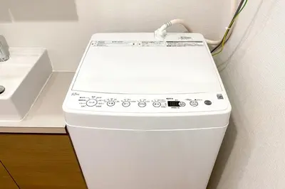 a washing machine in a bathroom next to a sink at \u30eb\u30fc\u30c1\u30a7\u9ad8\u8f2a in Tokyo