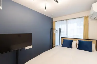 a bedroom with a bed and a flat screen tv at \u30ec\u30d4\u30e5\u30a2\u6771\u5411\u5cf6\u99c5\u524d\u30ec\u30b8\u30c7\u30f3\u30b9ll in Tokyo