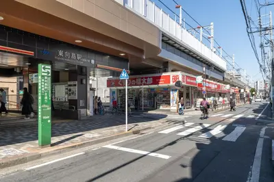 a busy city street with people walking and riding bikes at \u30ec\u30d4\u30e5\u30a2\u6771\u5411\u5cf6\u99c5\u524d\u30ec\u30b8\u30c7\u30f3\u30b9ll in Tokyo