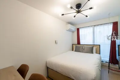 a bedroom with a bed and a ceiling fan at \u30ec\u30d4\u30e5\u30a2\u6771\u5411\u5cf6\u99c5\u524d\u30ec\u30b8\u30c7\u30f3\u30b9ll in Tokyo