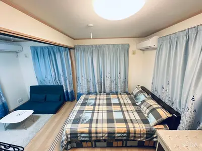 a small bedroom with a bed and a couch at \u65b0\u898fOPEN8\u5272\uff011\u68df\u8cb8\u5207\u30fb10\u540d\u53ef\u80fd\uff01\u79cb\u8449\u539f\u307e\u306713\u5206\u3001\u65b0\u5bbf\u307e\u306732\u5206\uff0f\u30b9\u30ab\u30a4\u30c4\u30ea\u30fc\u8fd1\u304f in Tokyo