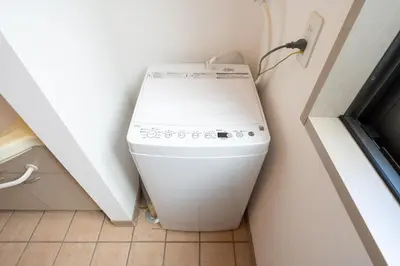 a washing machine sitting in a corner in a room at \u6771\u99d2\u5f622\u4e01\u76ee\u6238\u5efa in Tokyo