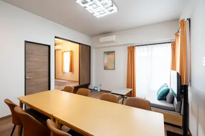 a room with a table and chairs and a couch at KAIGAN HAJIME Hub in Tokyo