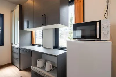 a kitchen with a microwave and a refrigerator at KAIGAN HAJIME Hub in Tokyo