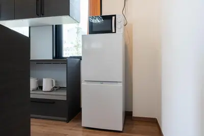 a white refrigerator with a microwave on top of it at KAIGAN HAJIME Hub in Tokyo
