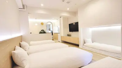 a living room with two white couches and a mirror at The Monica Residence ShinjukuGyoen in Tokyo