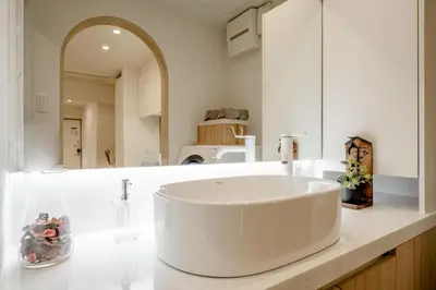 a white sink in a bathroom with a mirror at The Monica Residence ShinjukuGyoen in Tokyo